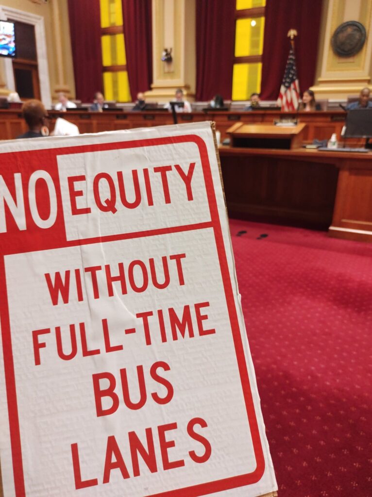 Hennepin for People sign: No equity without full-time bus lanes with city council members in background