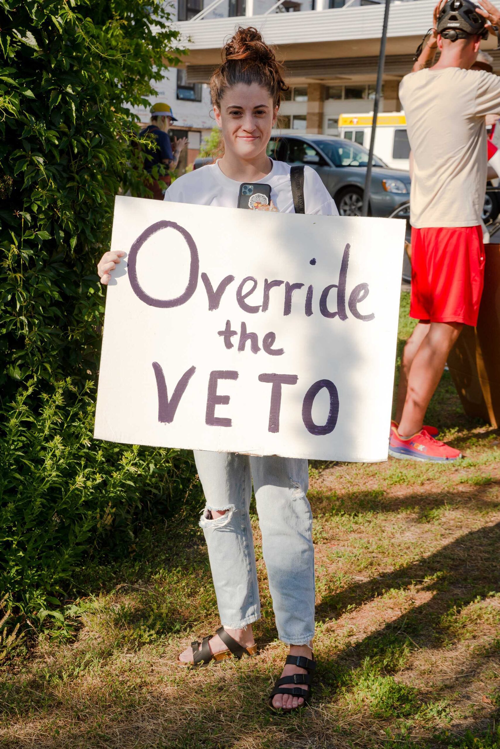 Person holding sign: Override the Veto
