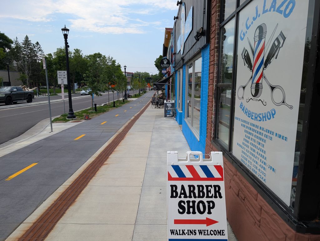 Businesses, sidewalk, and sidewalk level bike path